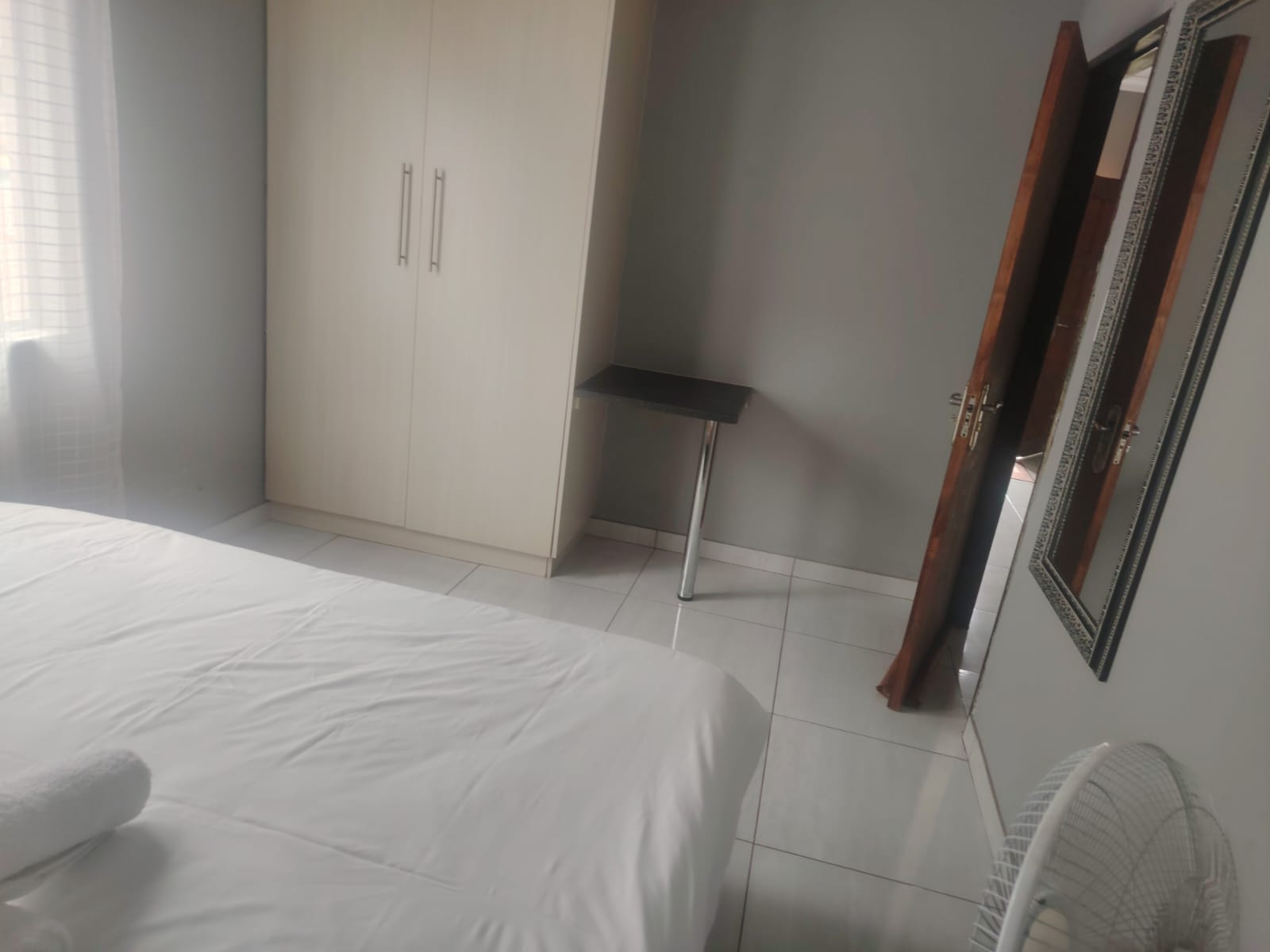 Apartment 4 double bed with nightstand and standing fan