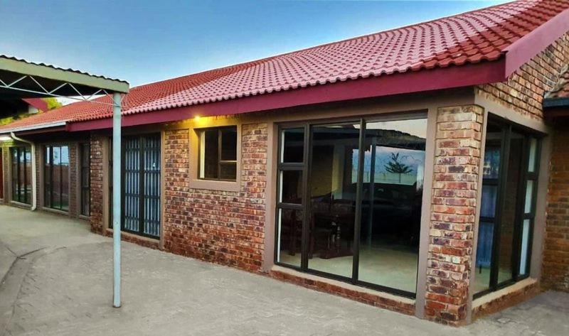Exterior of Zea85 B&B, a brick guesthouse with a red tile roof in Arcon Park, Vereeniging