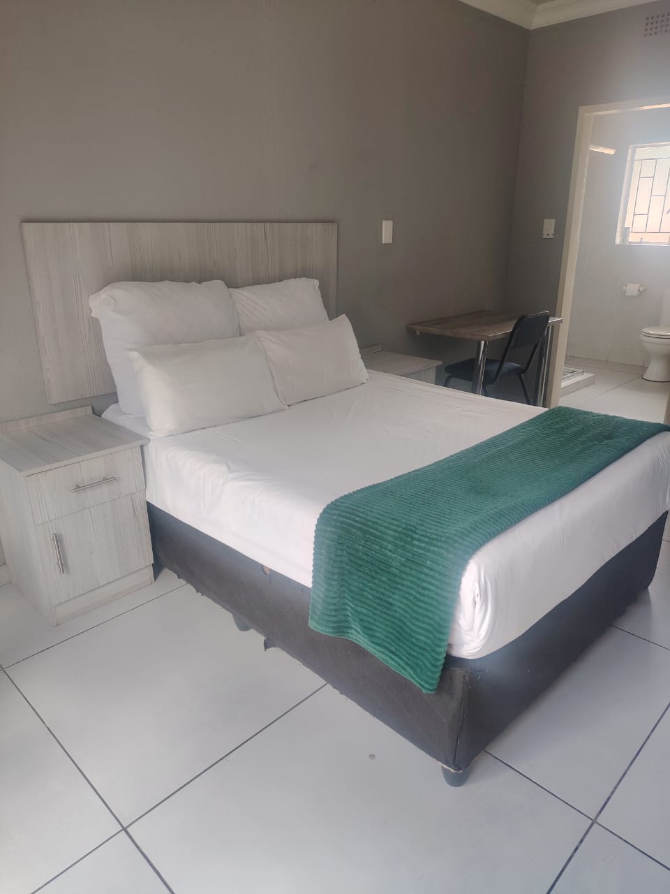 Double bed with green throw in an en-suite room at Zea85 B&B